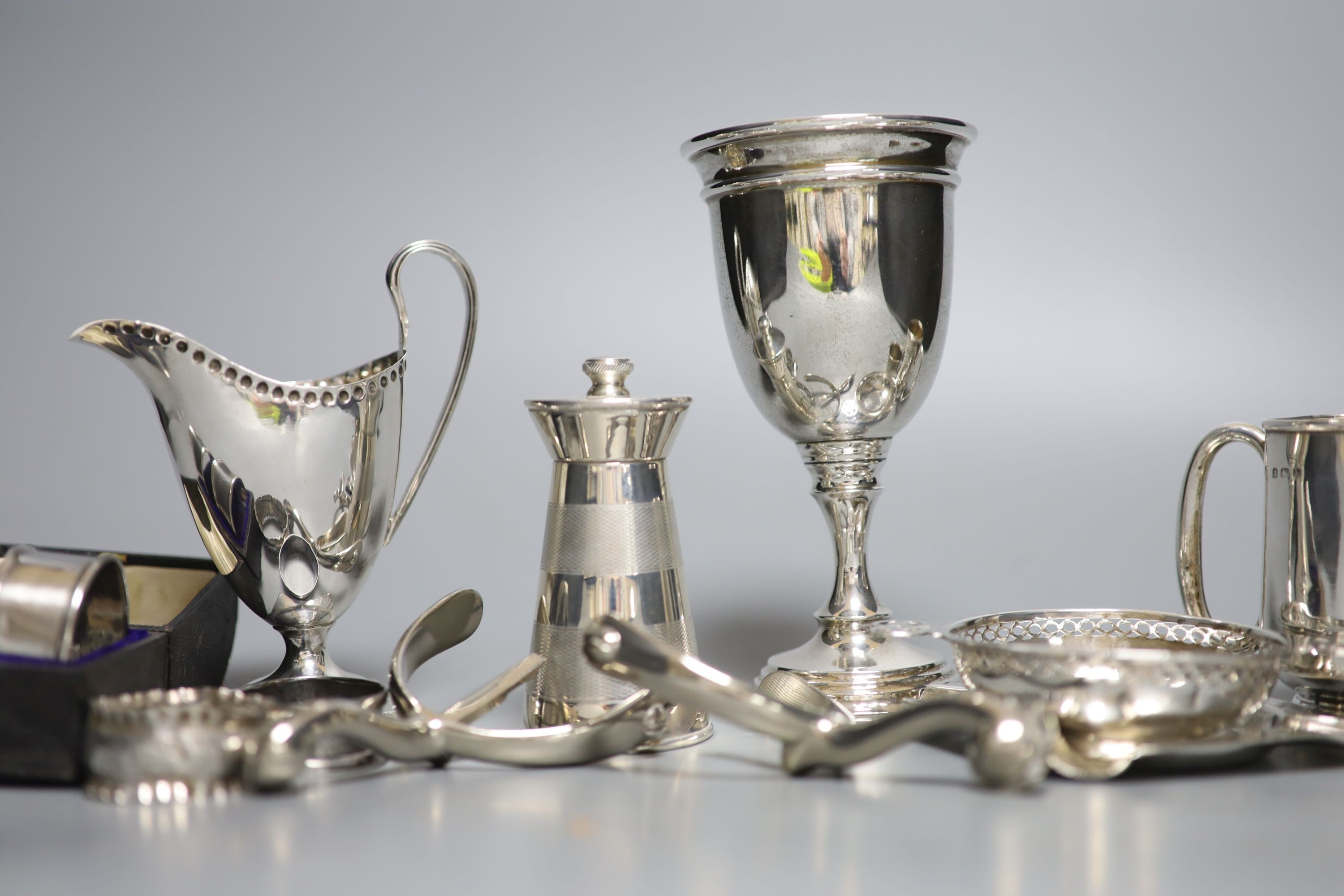 Mixed small silver lot to include a pepper mill, cream jug, christening mug, goblet, etc and a pair of metal spurs.